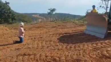 Idosa se ajoelha diante de máquina em protesto contra desapropriação para obra da Go-330